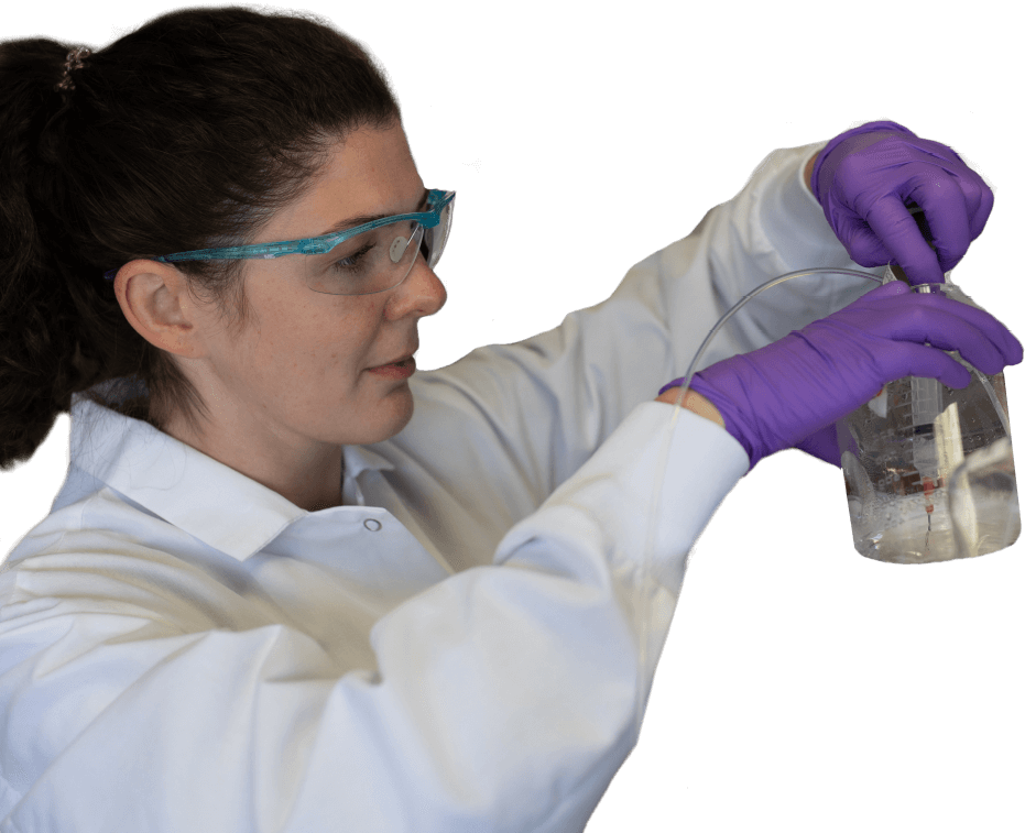 Female scientist examining the contents of a beaker.